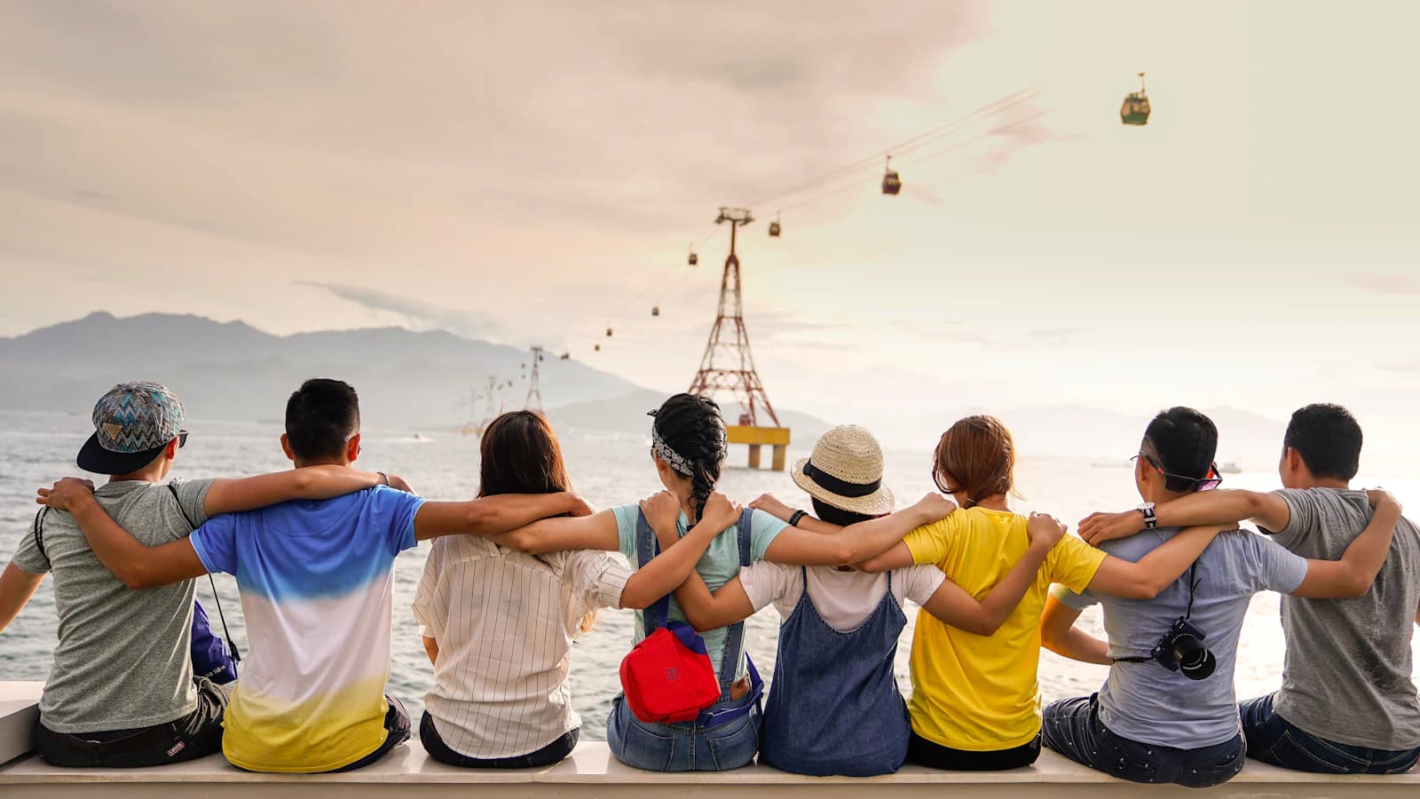 Friends sitting side by side with their arms around each other